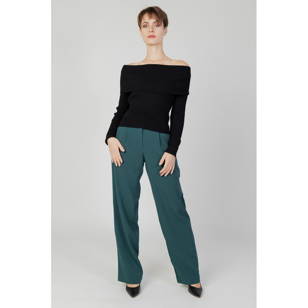 Woman wearing Vila Clothes Green Recycled Polyester Flared Pants with a black off-shoulder sweater; eco-friendly fashion.