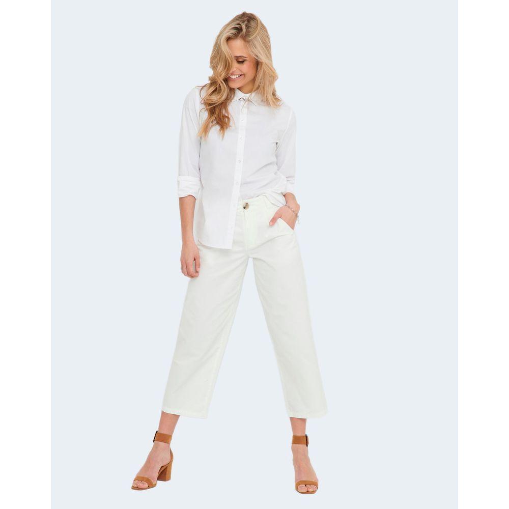 Woman wearing Jacqueline De Yong white cotton shirt and white pants, showcasing a stylish and versatile outfit for various occasions.