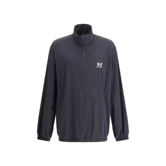 Black jacket with front zipper and collar, featuring a logo on the chest, long sleeves, and an elasticized hem.