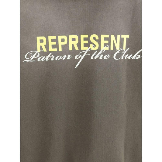Close-up of Represent hoodie with "Patron of the Club" text and yellow monogram on cotton fabric.
