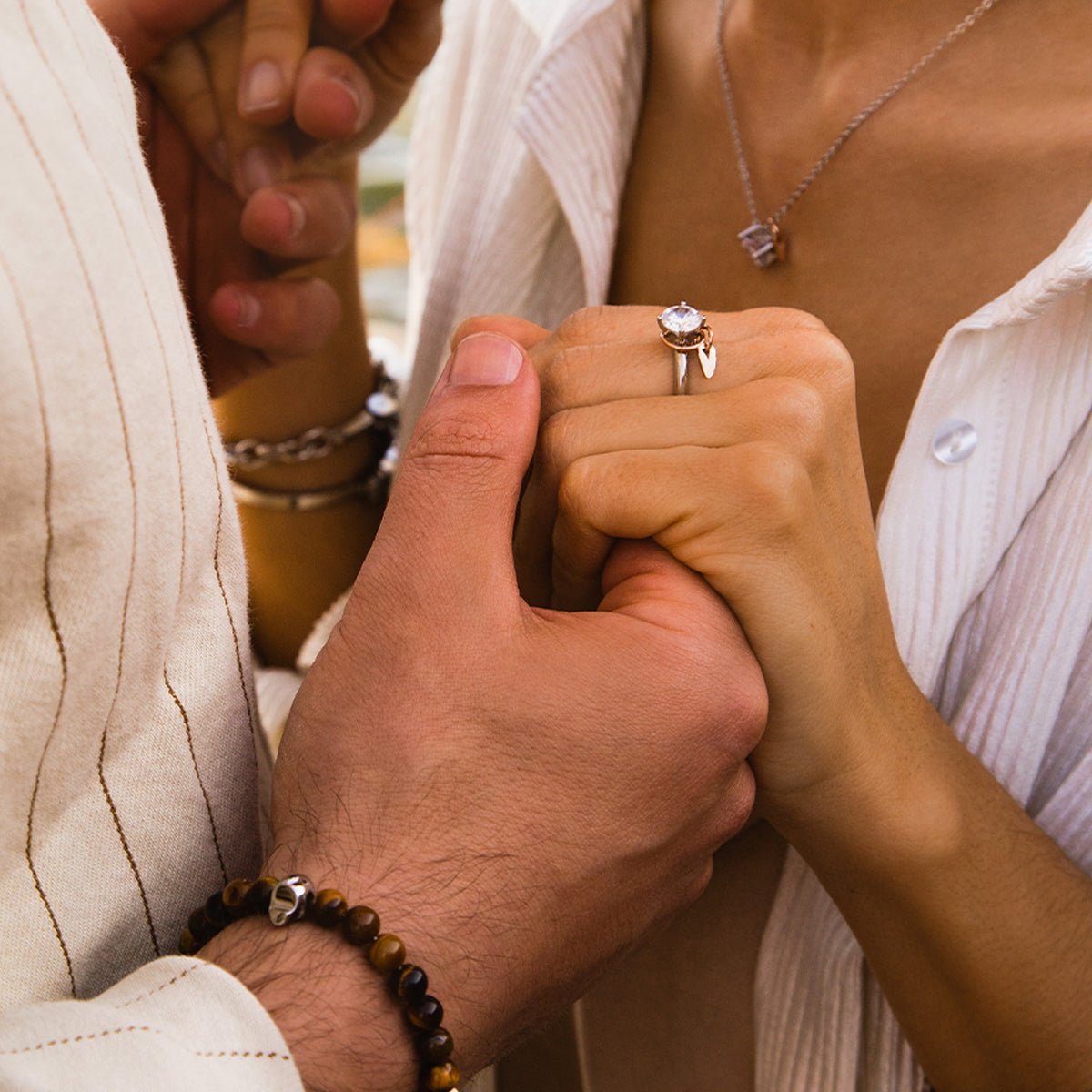 Couple holding hands featuring AN JEWELS JEWELRY Mod. AL.RLFY01-9 ring on woman's finger, showcasing elegance and style.