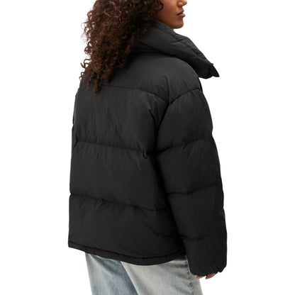 Woman wearing Calvin Klein Jeans Black Polyester Clothing puffer jacket for cold weather comfort and style.