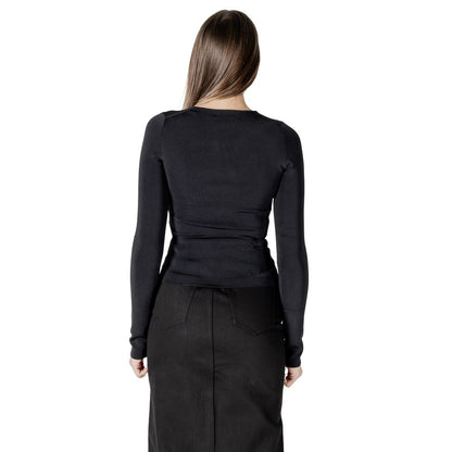 Back view of model wearing Calvin Klein Jeans Black Rayon Shirt with long sleeves and cut-out details.