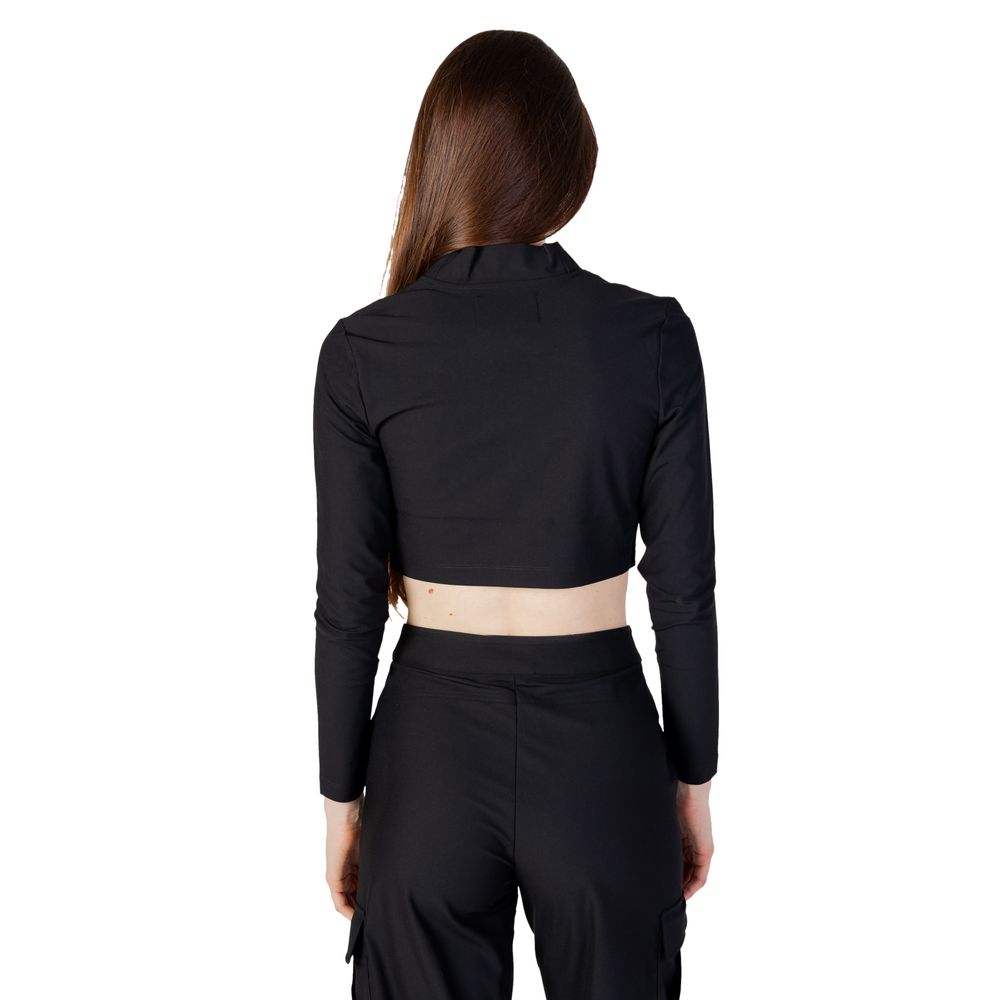 Back view of model wearing Calvin Klein Jeans Black Recycled Polyester Top with high collar and long sleeves, showing modern design.
