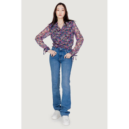 Woman wearing Guess Light Blue Organic Cotton Mom Jeans and floral blouse, showcasing high-waist fit and straight leg design.