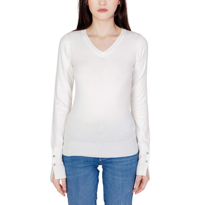 Woman wearing Guess White Cotton Sweatshirt with V-neck and decorative button sleeves, styled with jeans for a versatile look.