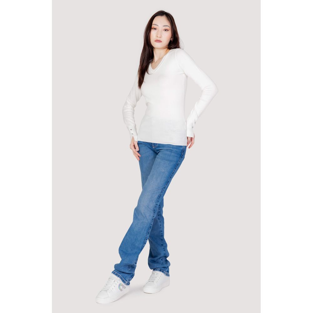 Woman wearing Guess White Cotton Sweatshirt with jeans and sneakers, showcasing a casual yet elegant style.