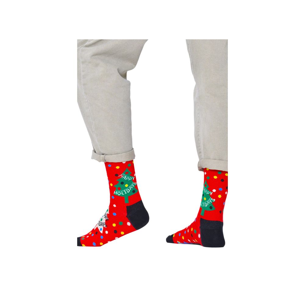 Happy Socks Red Cotton Socks with festive Christmas design and 'Happy Holidays' message, worn with beige pants, showcasing playful style.