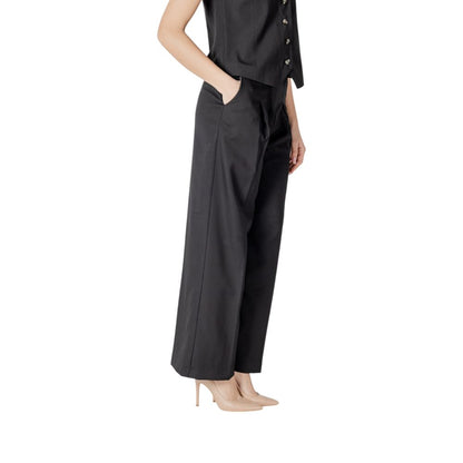 Woman wearing ICHI Black Polyester Pant, showcasing modern palazzo style with wide cut and front pleats for elegance and comfort.