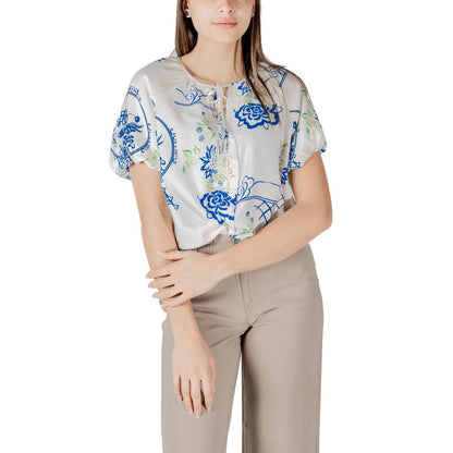 Woman wearing ICHI White Viscose Shortsleeve top with floral pattern, paired with beige pants, highlighting a summery and elegant style.