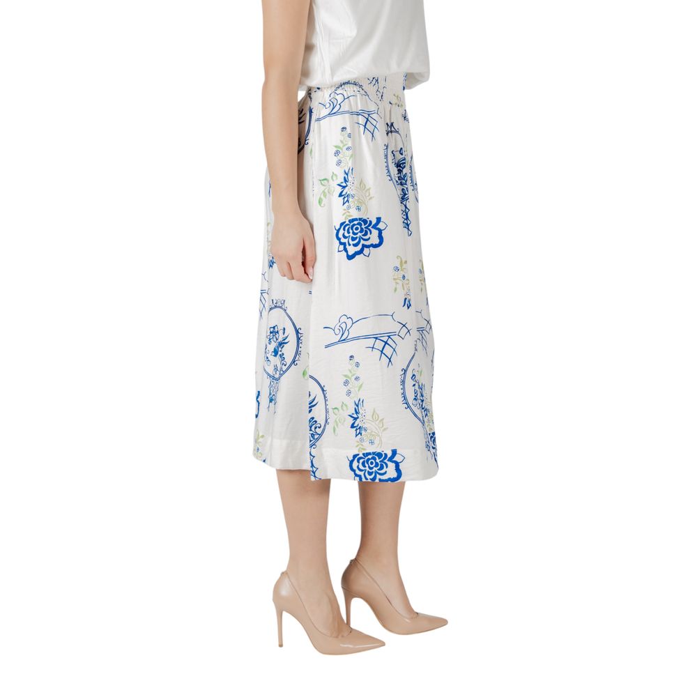Side view of woman wearing ICHI White Viscose Skirt with blue floral pattern, highlighting its flowing design and comfortable fit.