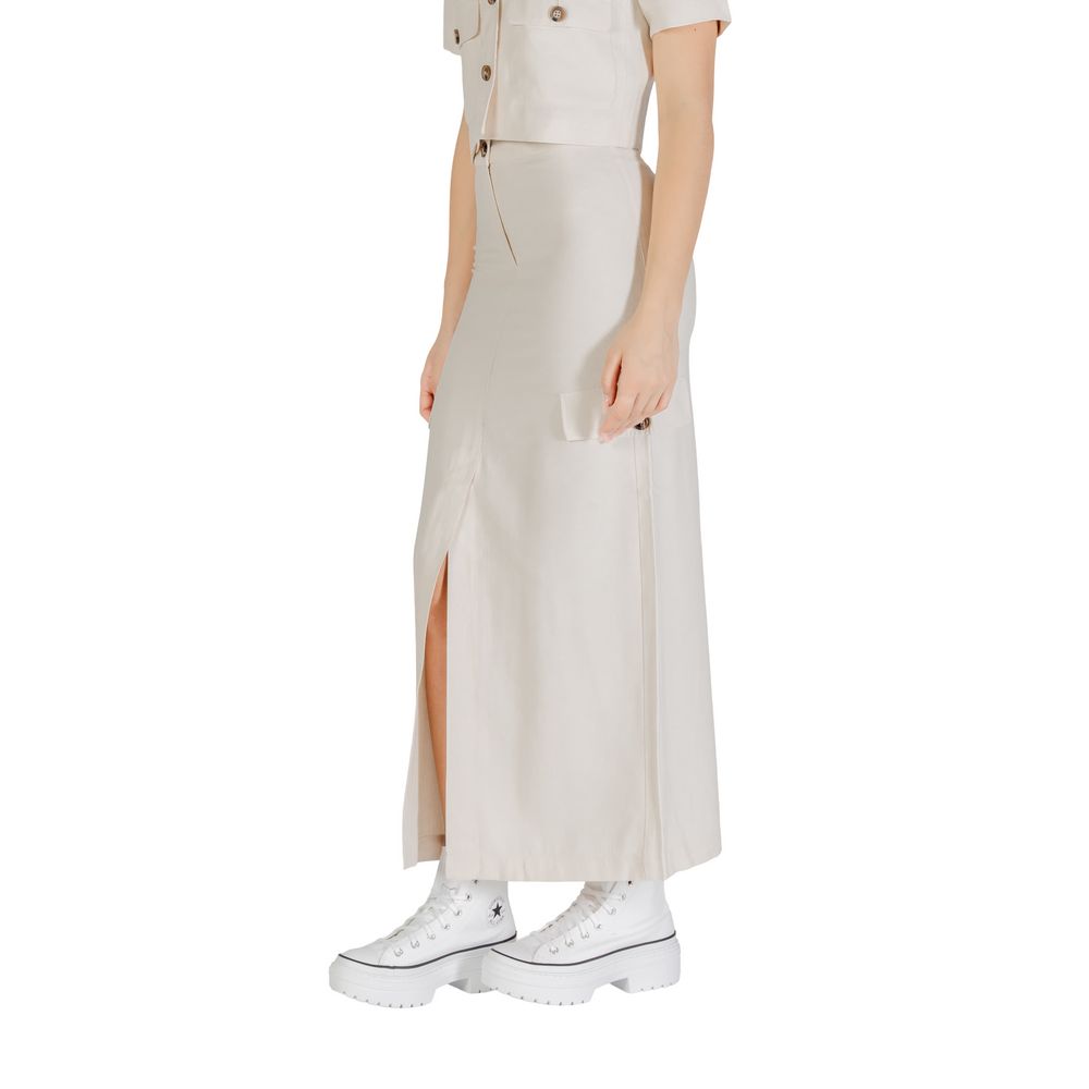 Woman wearing Jacqueline De Yong Bicolor Viscose Long Skirt in beige with side slit and pockets, styled with white sneakers.