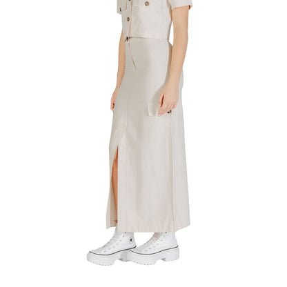 Woman wearing Jacqueline De Yong Bicolor Viscose Long Skirt in beige with side slit and pockets, styled with white sneakers.