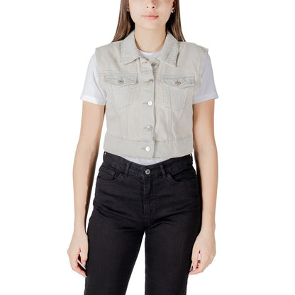 Woman wearing Only Light Blue Cotton Sleveless Jacket with metallic buttons and front pockets, paired over a t-shirt and pants.