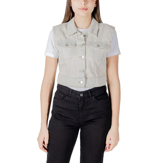 Woman wearing Only Light Blue Cotton Sleveless Jacket with metallic buttons and front pockets, paired over a t-shirt and pants.