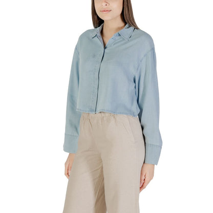 Only Light Blue Lyocell Blouse with long sleeves and cropped design, paired with neutral trousers, offering a casual yet elegant look.