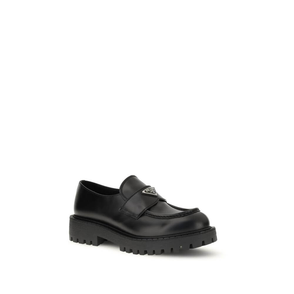 Prada Black Calf Leather Bos Taurus Slip-On Loafers with enameled metal triangle and rubber sole. AW25 collection.