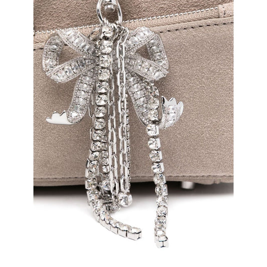 Close-up of silver-tone hardware and bow detailing on Self-Portrait suede baguette shoulder bag, featuring grey suede material.