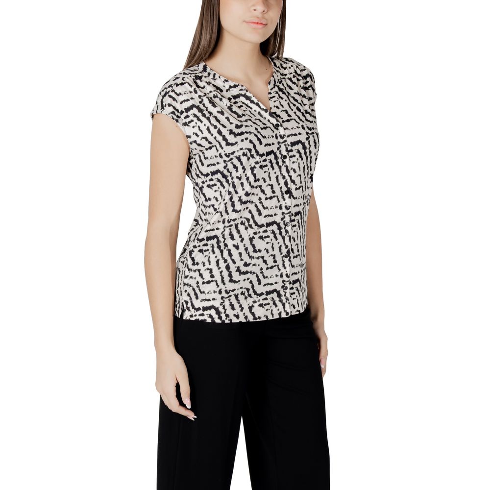 Woman wearing stylish street one cream cotton t-shirt with unique print and button panel, short sleeves, paired with black trousers