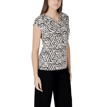 Woman wearing stylish street one cream cotton t-shirt with unique print and button panel, short sleeves, paired with black trousers