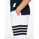 Thom Browne Trousers White with elasticated drawstring waistband, side slit pockets, logo patch, and grosgrain loop tab.