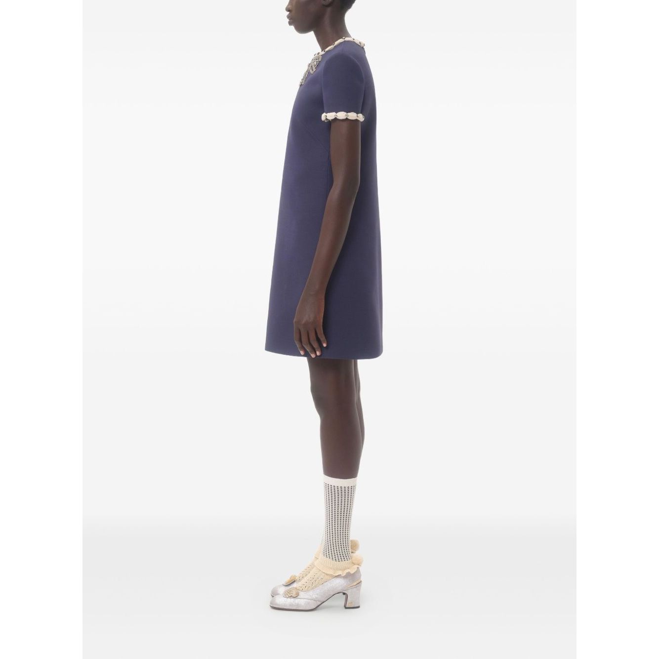 Side view of a navy blue Valentino Short Embroidered Crepe Couture Dress with rhinestone embellishments and contrasting trim.