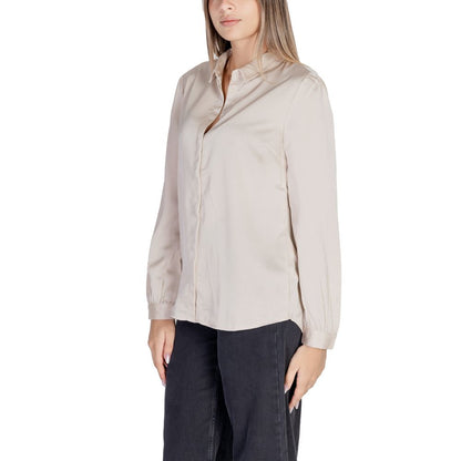 Woman wearing Vila Clothes Gold Polyester Blouse with satin texture, long-sleeve design, and elegant collar for versatile styling.